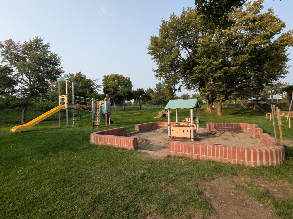 島津公園の幼児向け遊具とレンガで囲まれた大きな砂場