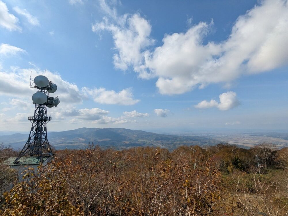 カムイスキーリンクス山頂の展望デッキからの眺め。色づいた木々の向こうに山と平野が見える（2026年10月10日撮影）